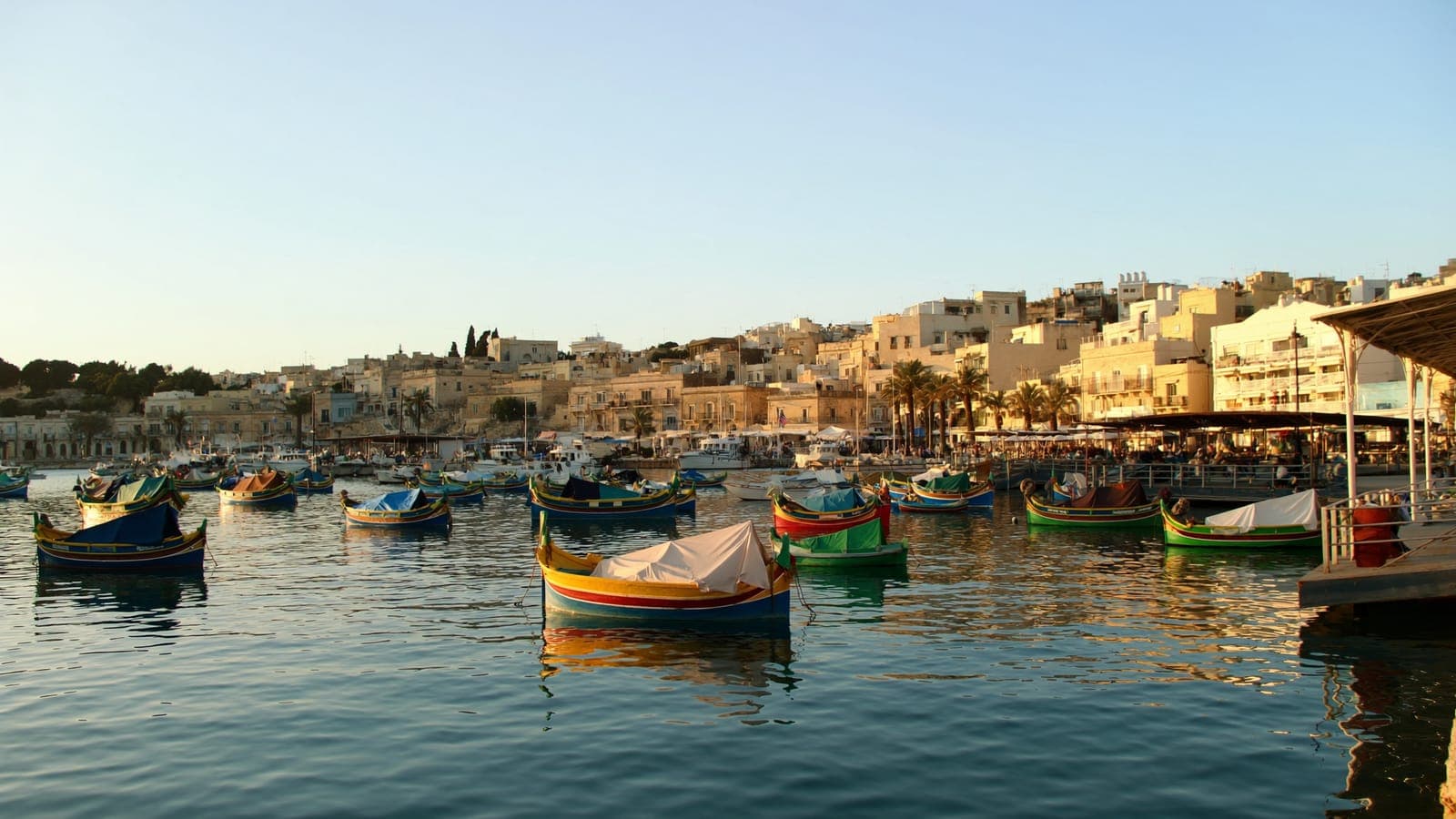 Marsaxlokk fishing village and its luzzu boats at golden hour
