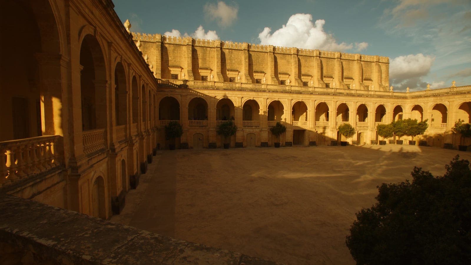 A historic Maltese university courtyard at golden hour