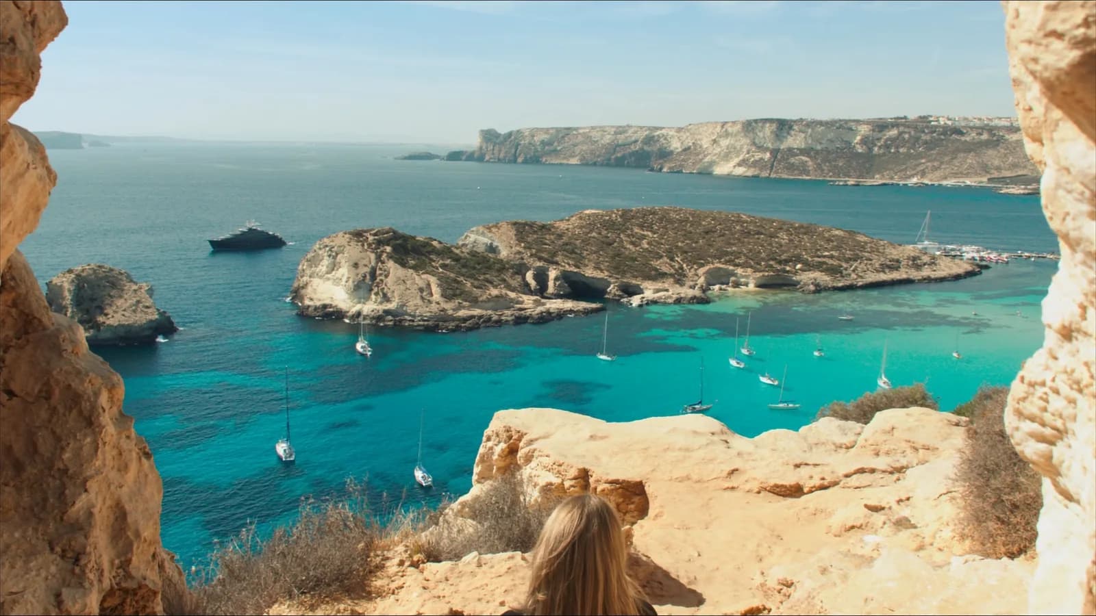 Turquoise Blue Lagoon water and limestone coast near Comino with anchored boats
