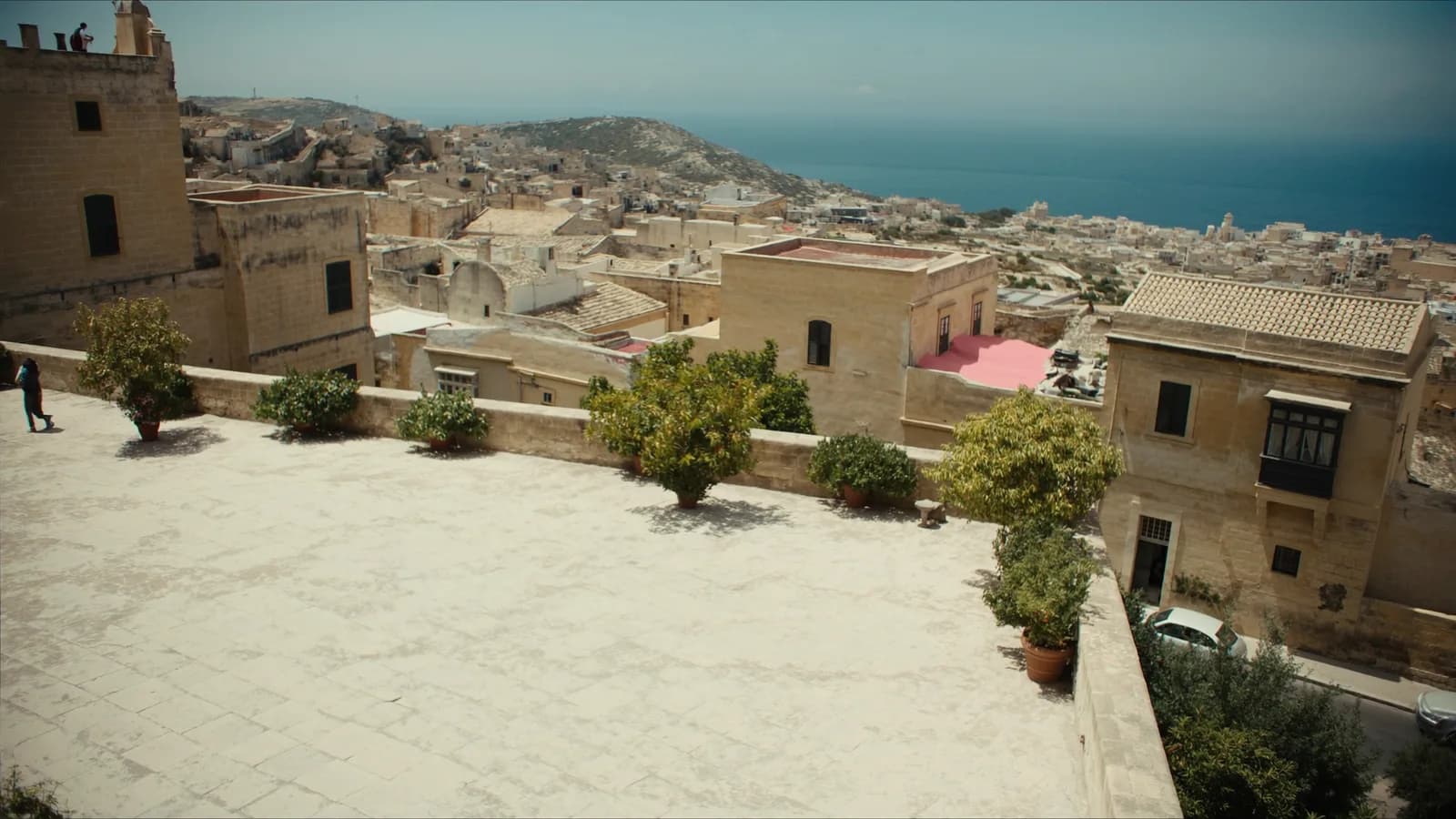 Sunlit Maltese limestone town opening toward the Mediterranean sea